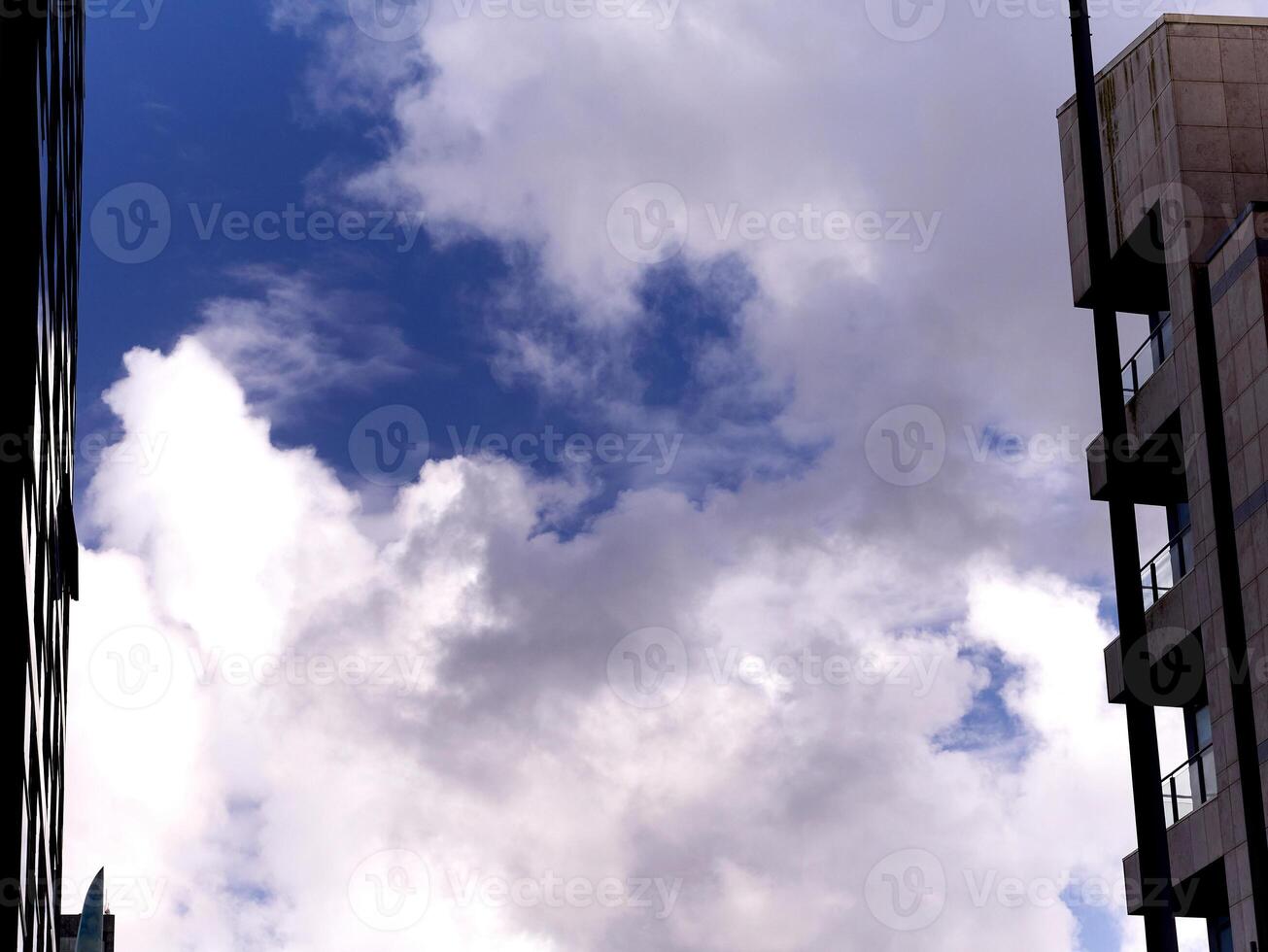 White fluffy clouds between apartment buildings, clouds background photo