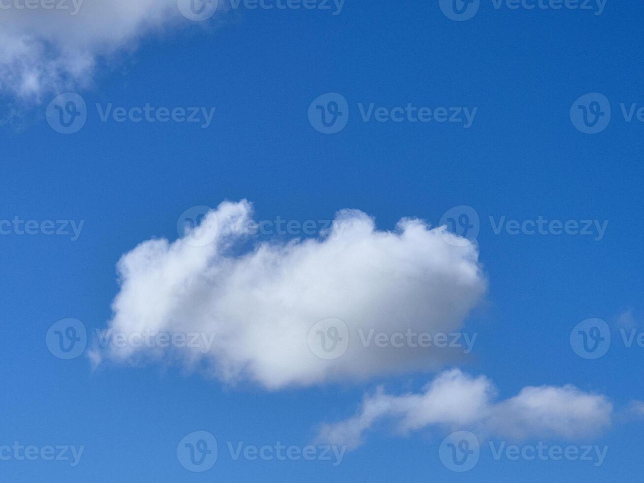 Single white fluffy cumulus cloud in the blue summer sky photo