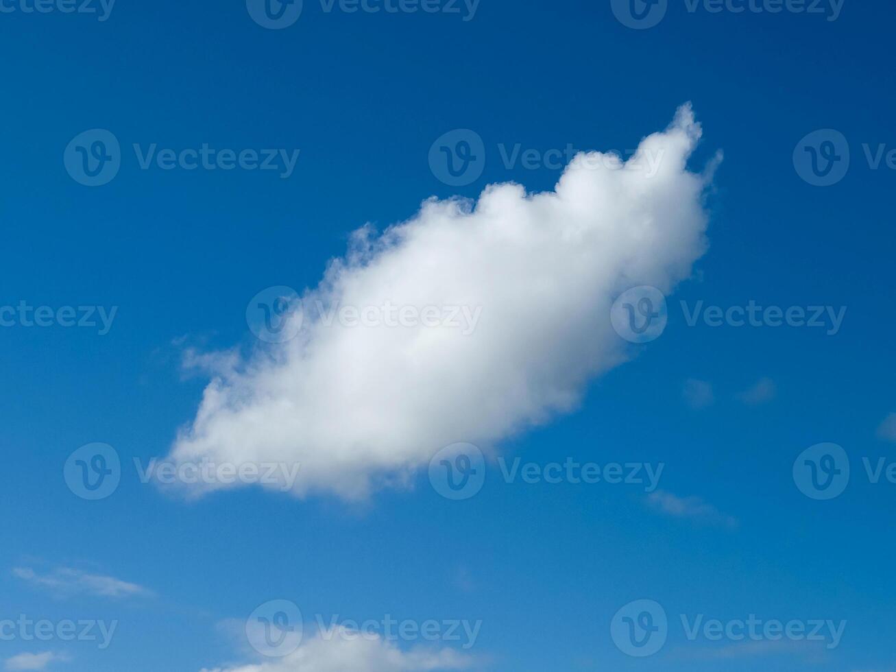 Single white fluffy cumulus cloud in the blue summer sky photo