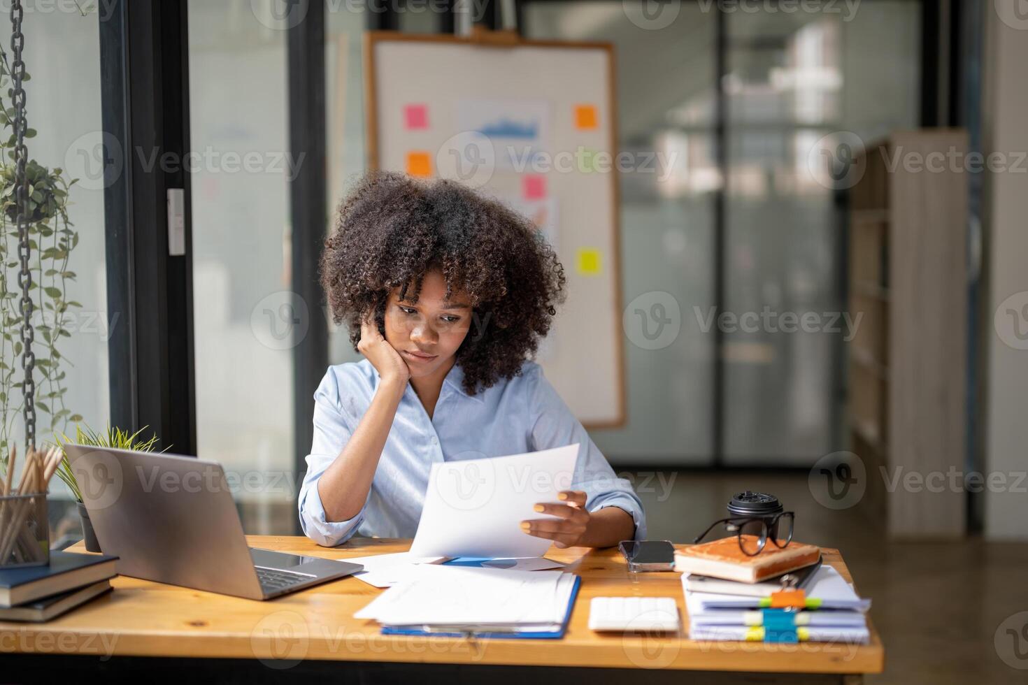 business woman sitting and looking at documents or work that is going on. Stressed business woman analyst looking at paperwork. photo