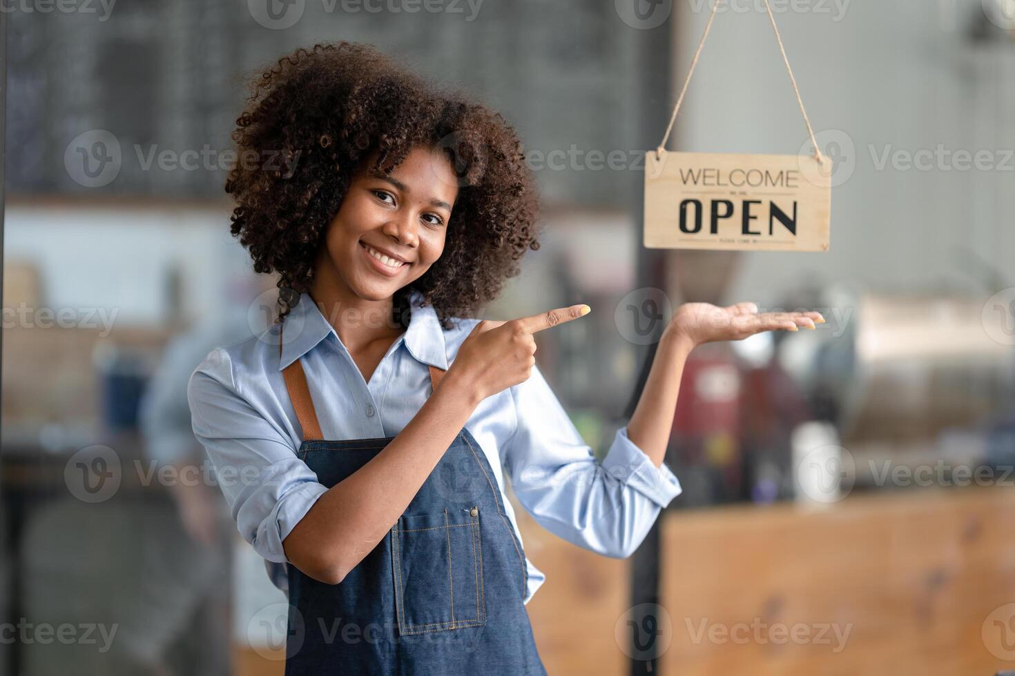 Successful african american woman in apron standing coffee shop door. Happy small business owner. Smiling portrait of entrepreneur standing with copy space. photo