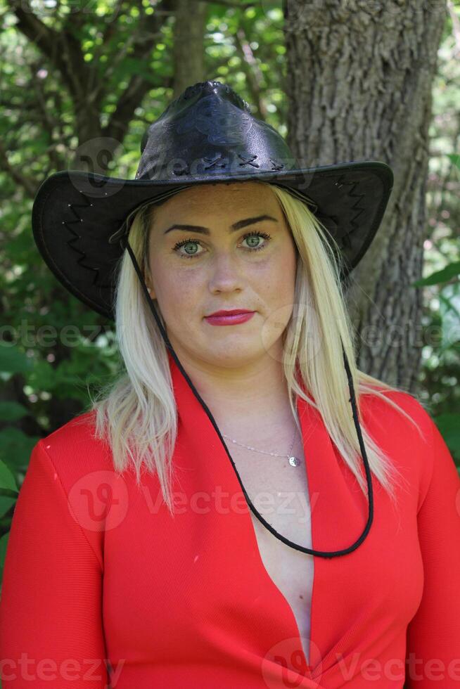 A Beautiful Cowgirl in a Black Hat and a Red Dress. photo