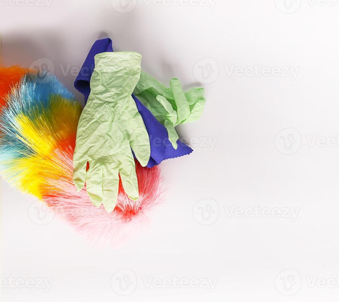 Rubber gloves, the duster and microfiber cloth on light background photo
