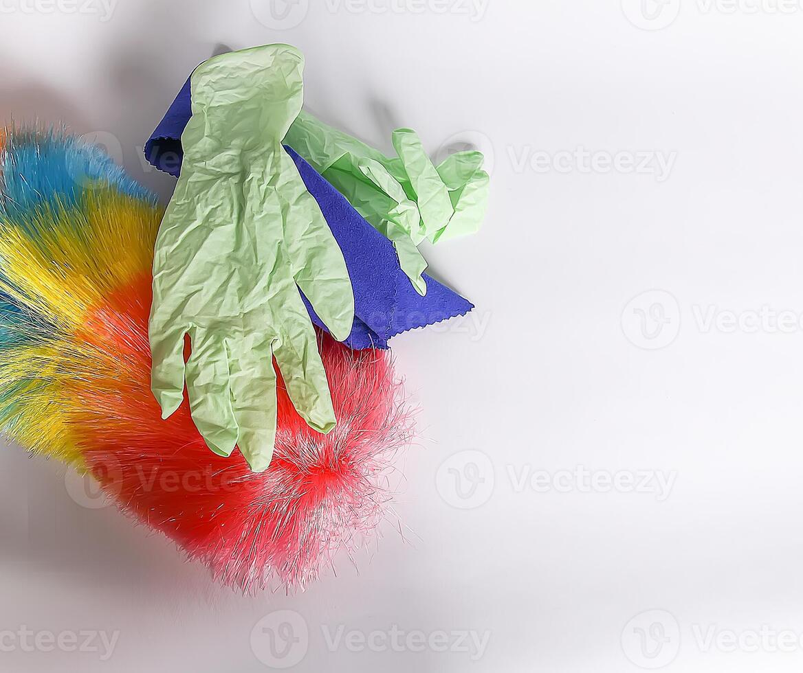 Rubber gloves, the duster and microfiber cloth on light background photo