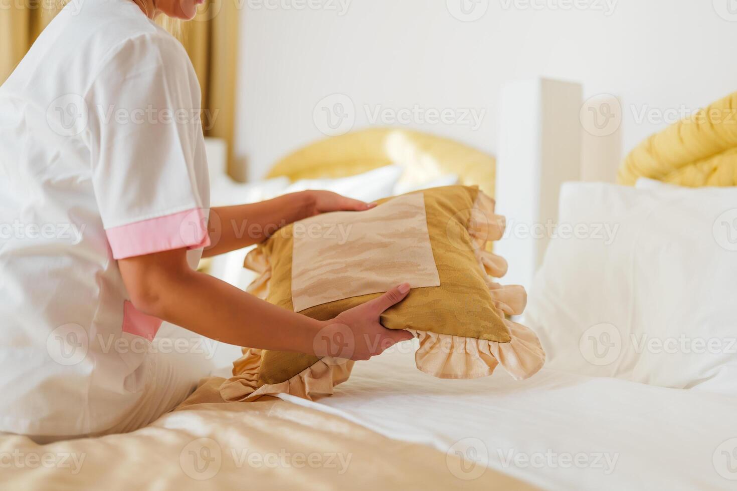Close up image of hotel maid making bed in a room. photo