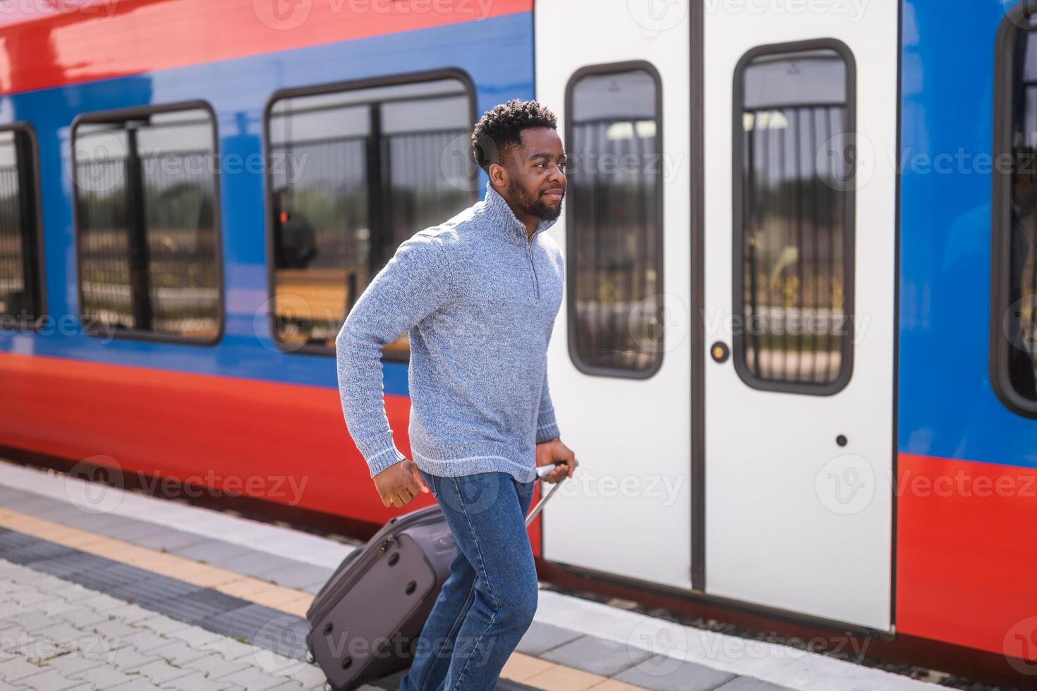 hombre corriendo a un dejando tren a lo largo ferrocarril estación con maleta. foto