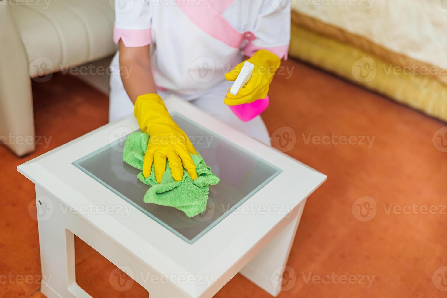 Close up image of hotel maid cleaning table in a room. photo