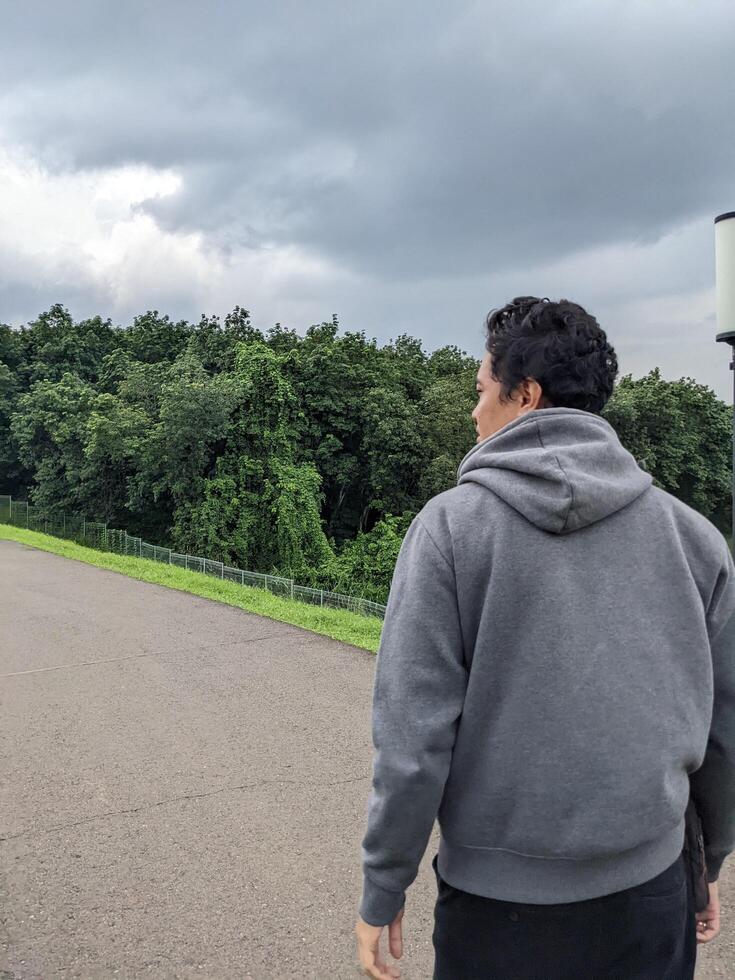 hombre caminando en el parque cuando día tiempo. el foto es adecuado a utilizar para calma disfruté actividad, ocio actividad y parque antecedentes.