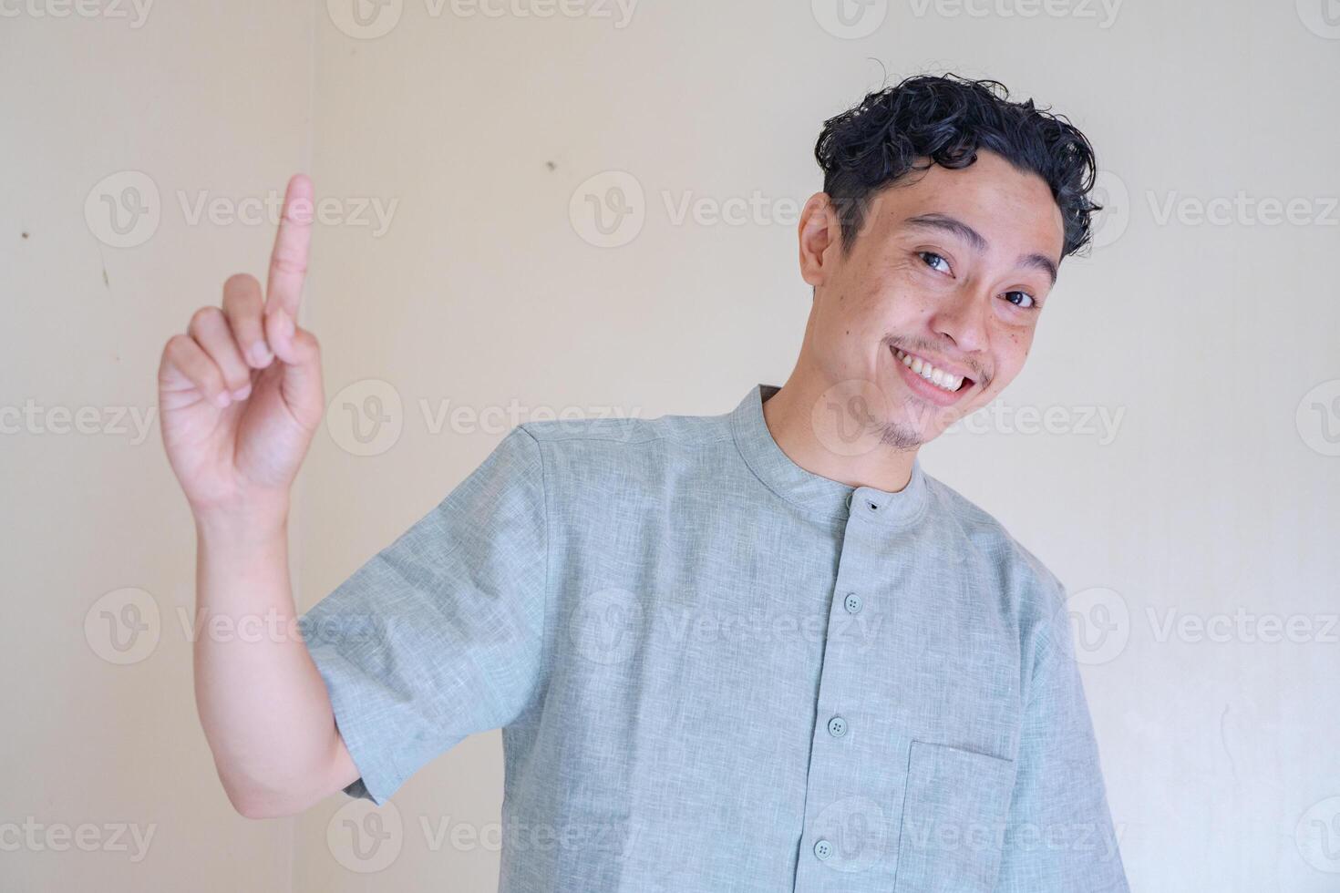 Moslem Asian man pointing the link gesture when Ramadan celebration. The photo is suitable to use for Ramadhan poster and Muslim content media.