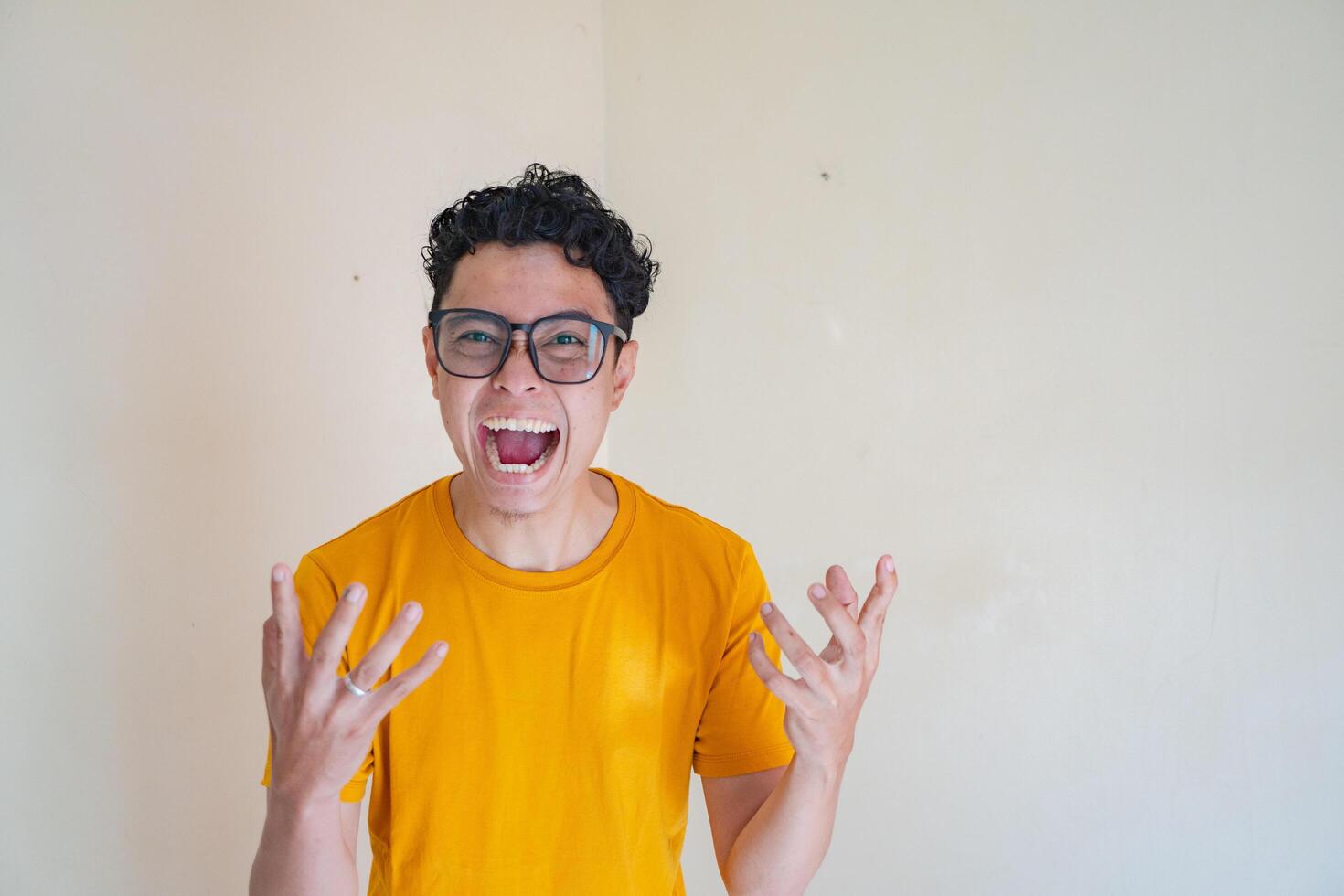 Young Indonesian man wear glasses with angry expression. The photo is suitable to use for man expression advertising and fashion life style.