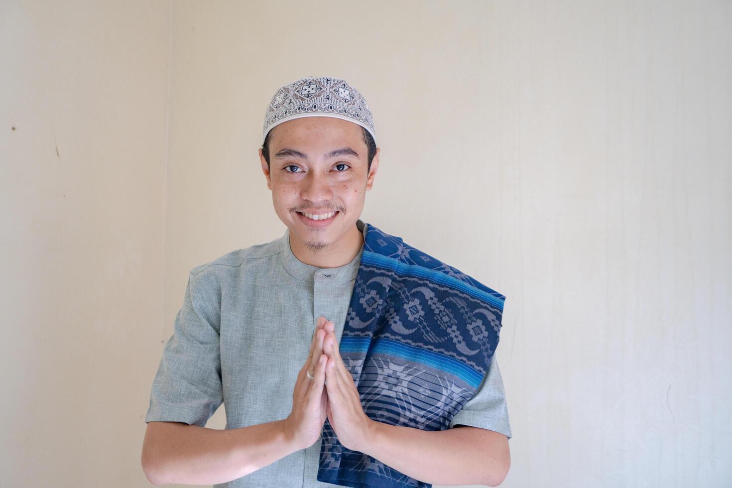 Moslem Asian man greeting gesture with smile when Ramadan celebration. The photo is suitable to use for Ramadhan poster and Muslim content media.