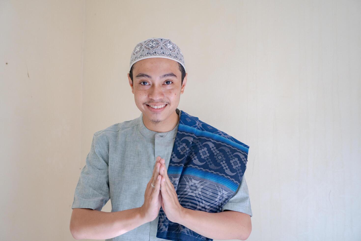 musulmán asiático hombre saludo gesto con sonrisa cuando Ramadán celebracion. el foto es adecuado a utilizar para ramadhan póster y musulmán contenido medios de comunicación.