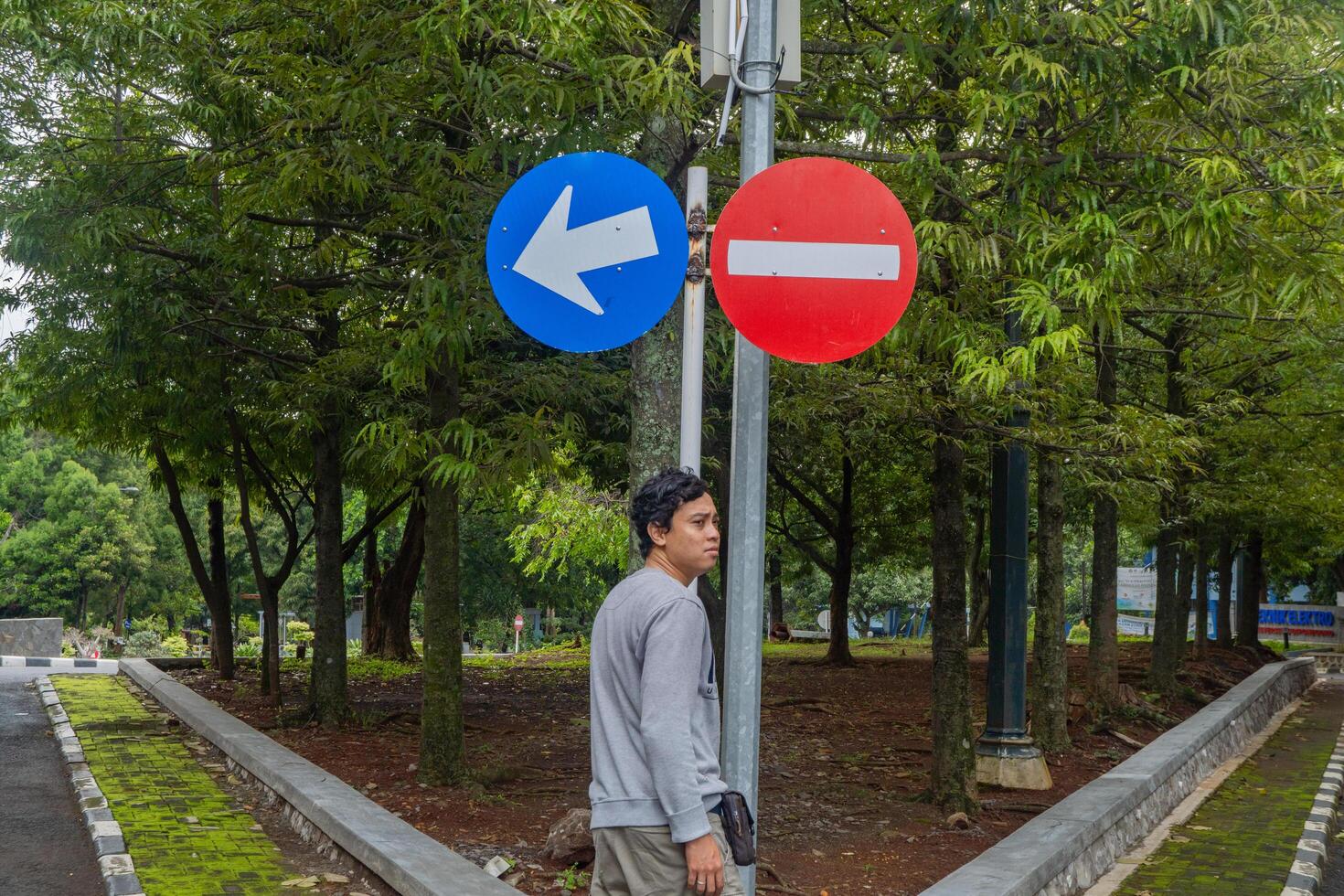 Man look to the sign direction traffic. The photo is suitable to use for adventure and travel destination content media.