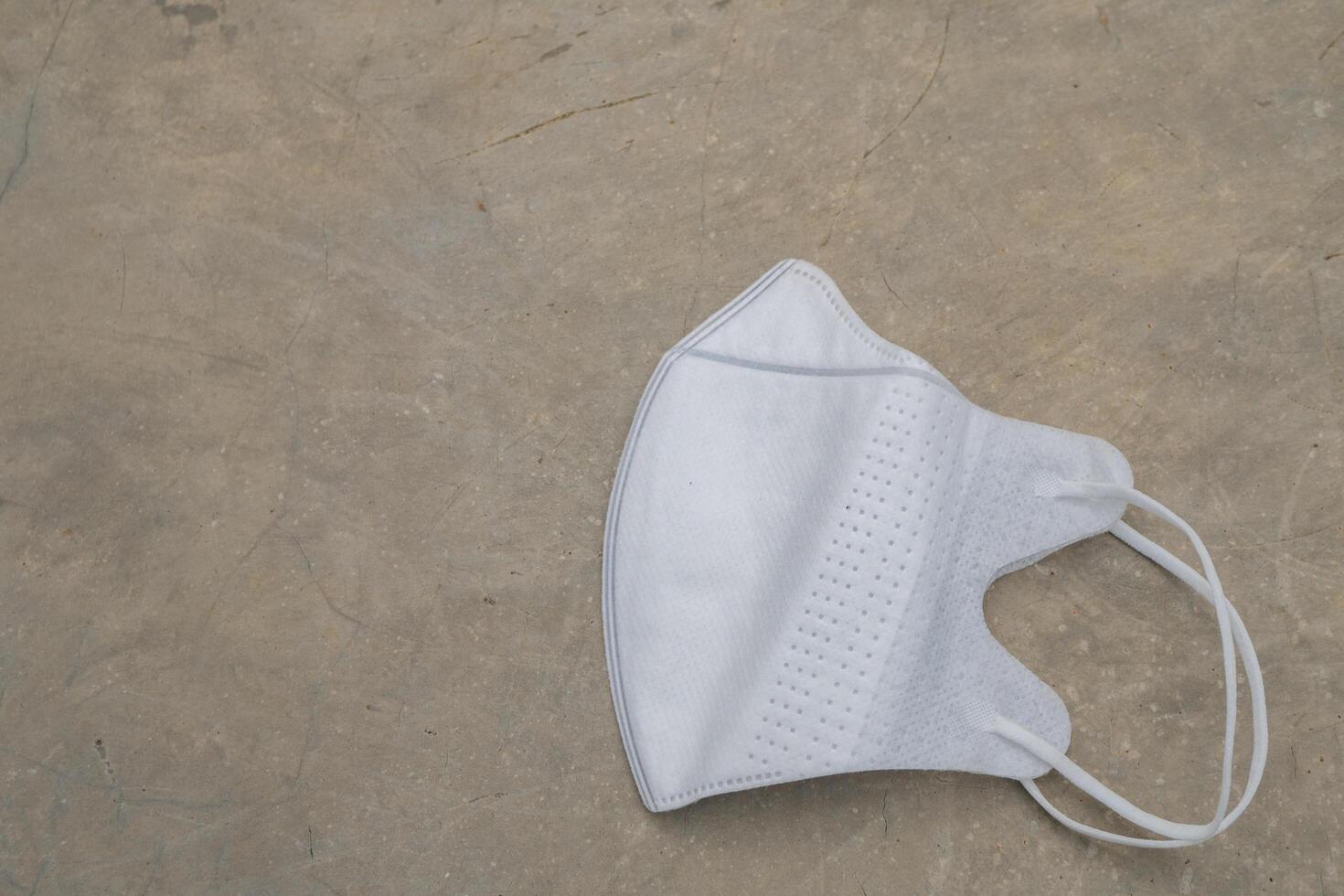 White face mask over the floor. The photo is suitable to use for health background and content media.