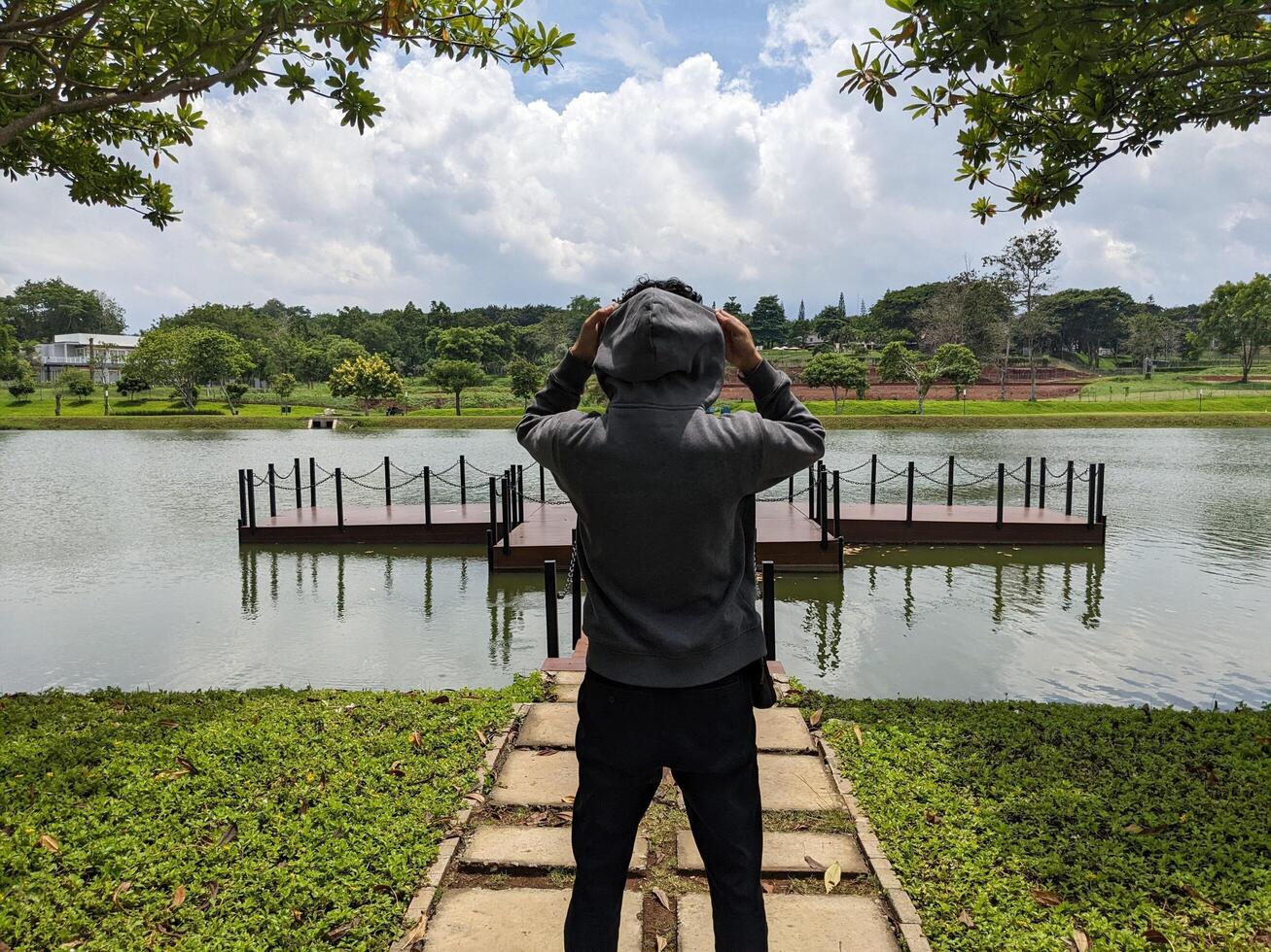 Man stand in front of the way lake on down town. The photo is suitable to use for adventure content media, nature poster and forest background.