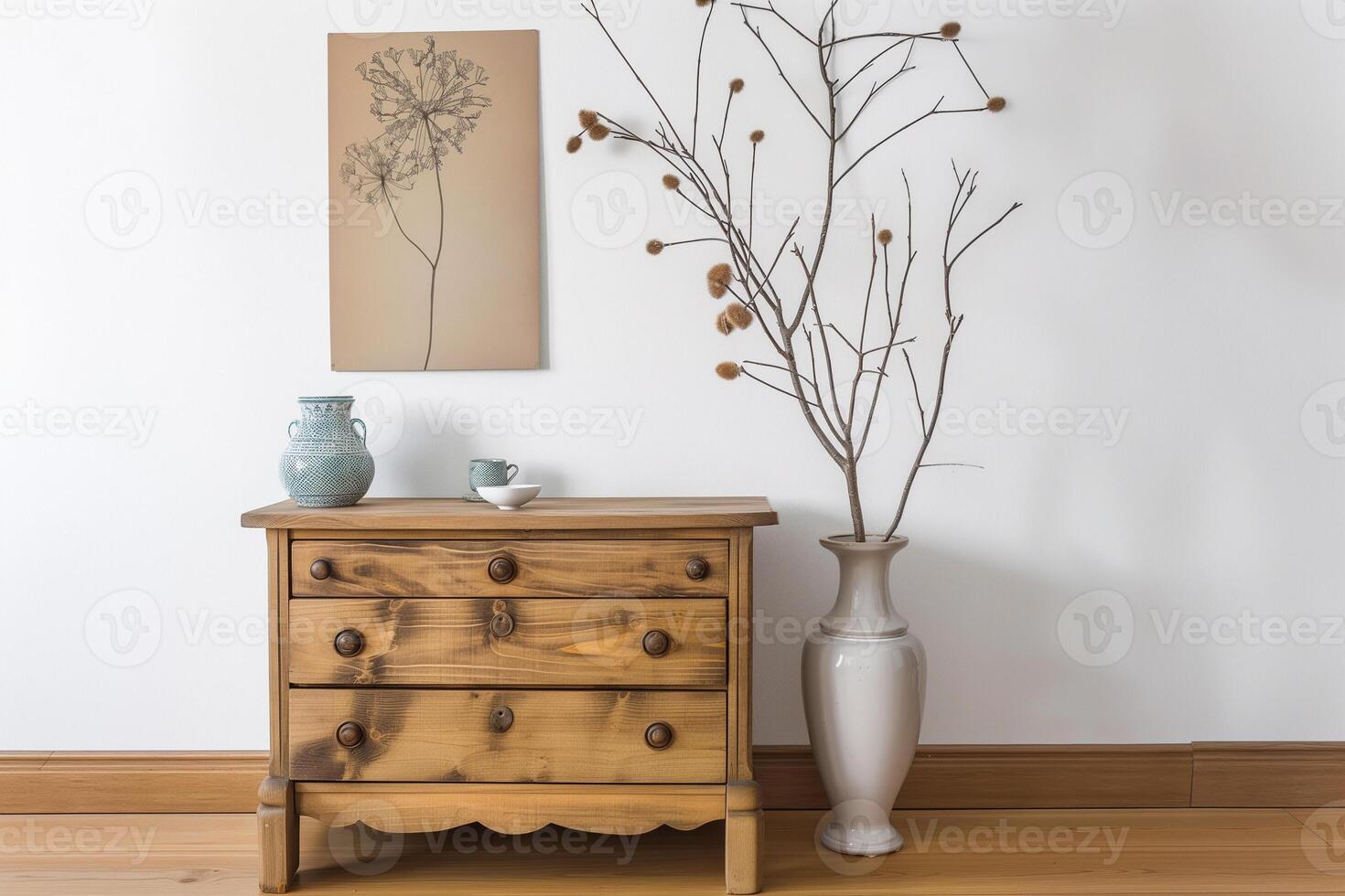 Vintage wooden chest of drawers with a porcelain vase, a dry branch and a poster on a white wall photo