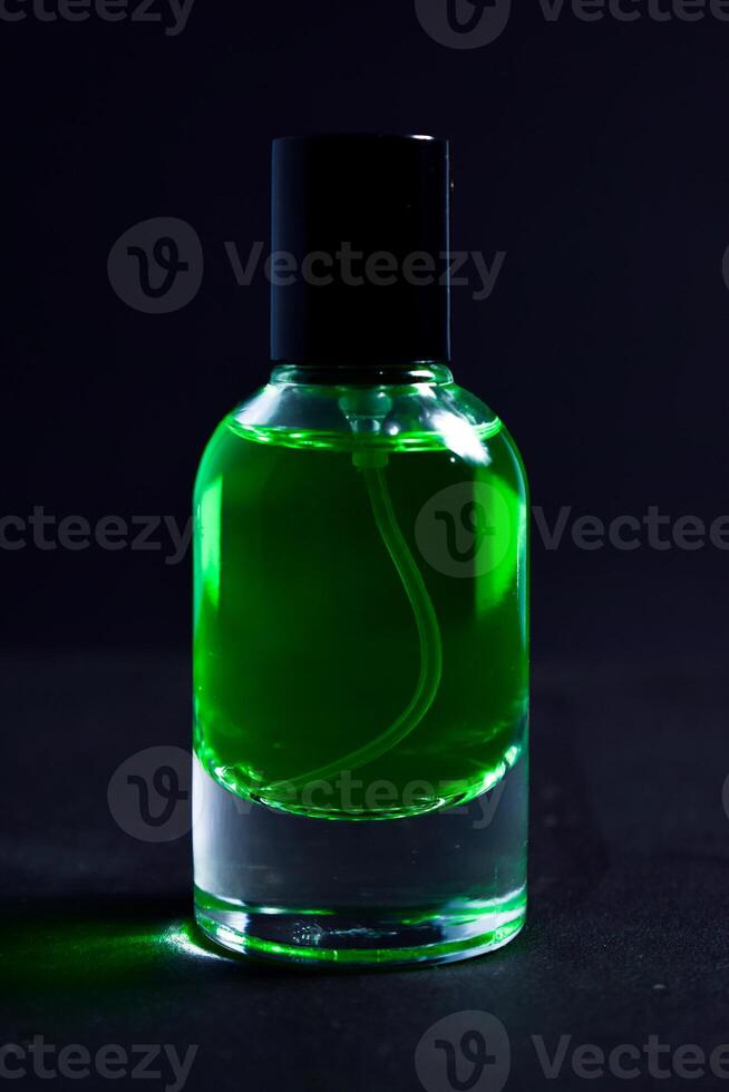 Transparent Dark green Bottle Perfume isolated black background for mock up design photo