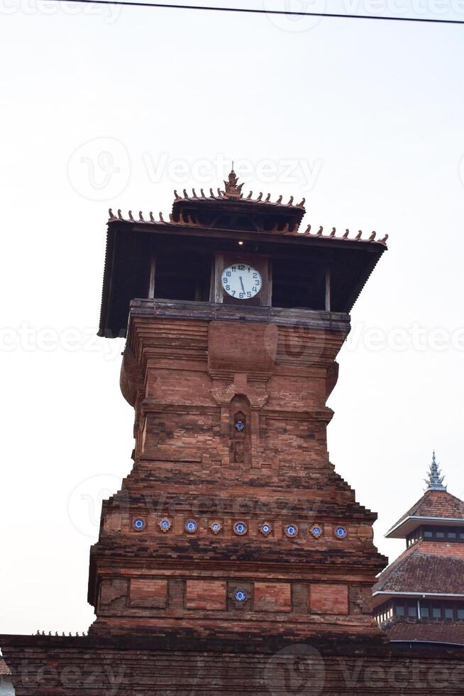 February 29, 2024. Kudus, Indonesia. Historical Tower of KUDUS central java indoesia with white big white clock. One of the Oldest Mosques in Indonesia photo