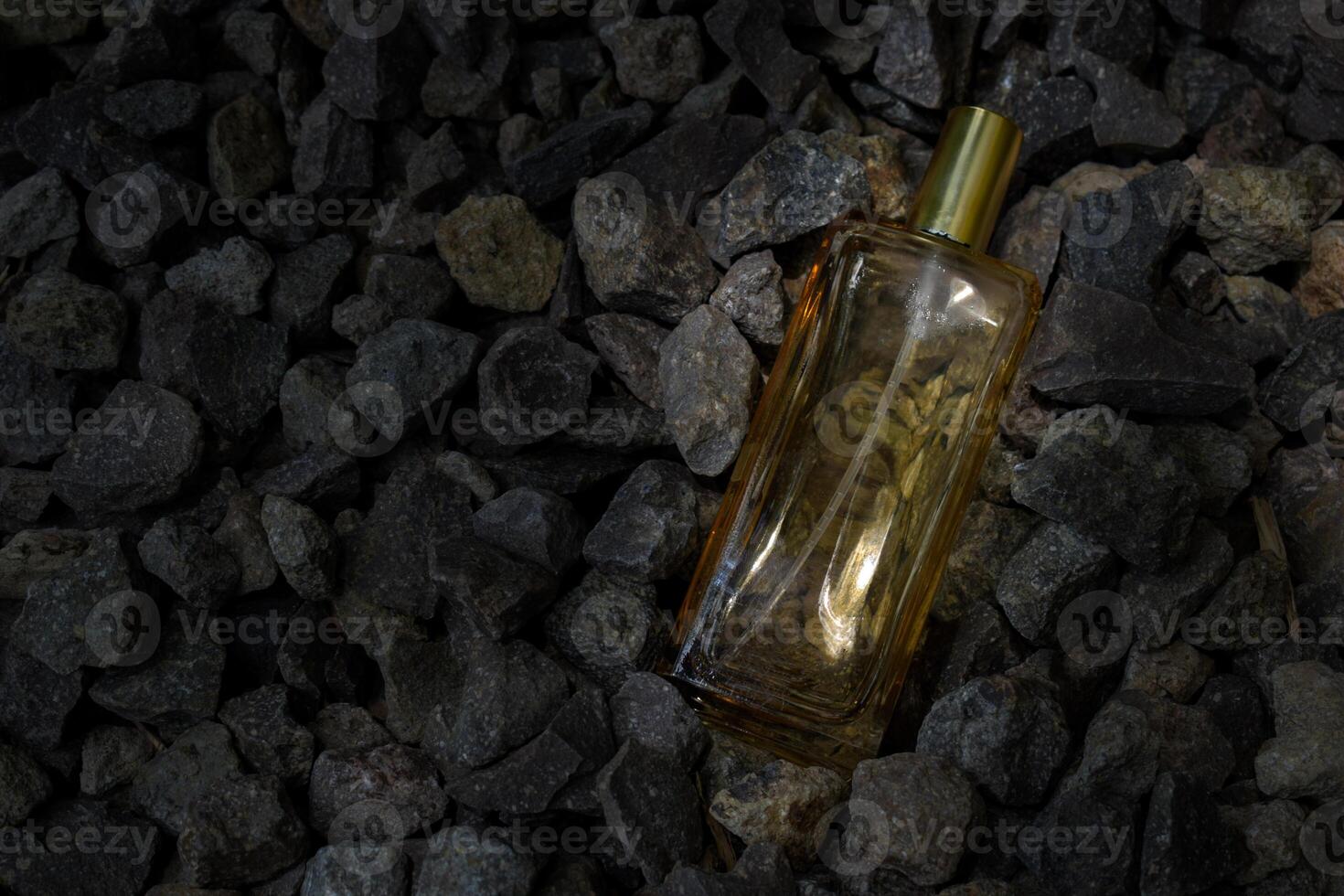 Perfume Gold transparent bottle in gravel or coral background photo