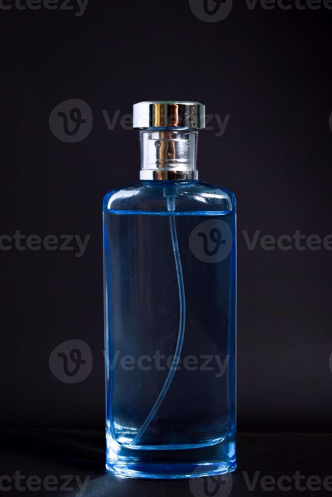 Transparent Blue Bottle Perfume isolated black background for mock up design photo