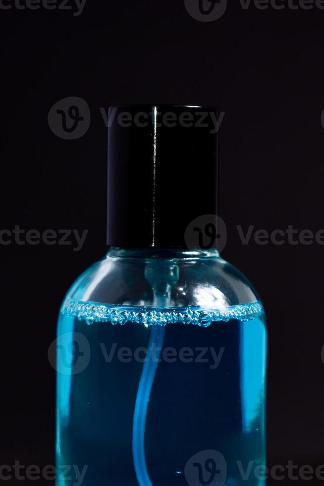 Transparent Blue Bottle Perfume isolated black background for mock up design photo