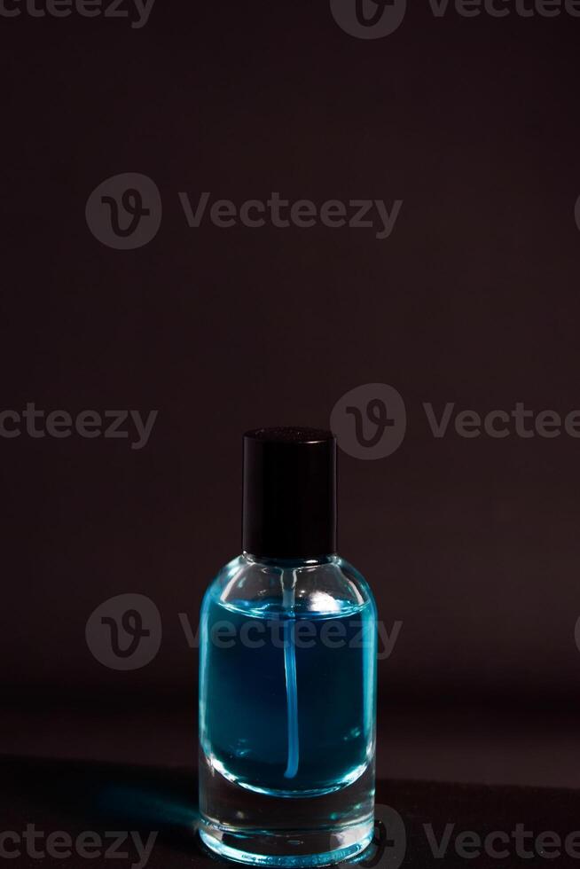 Transparent Blue Bottle Perfume isolated black background for mock up design photo