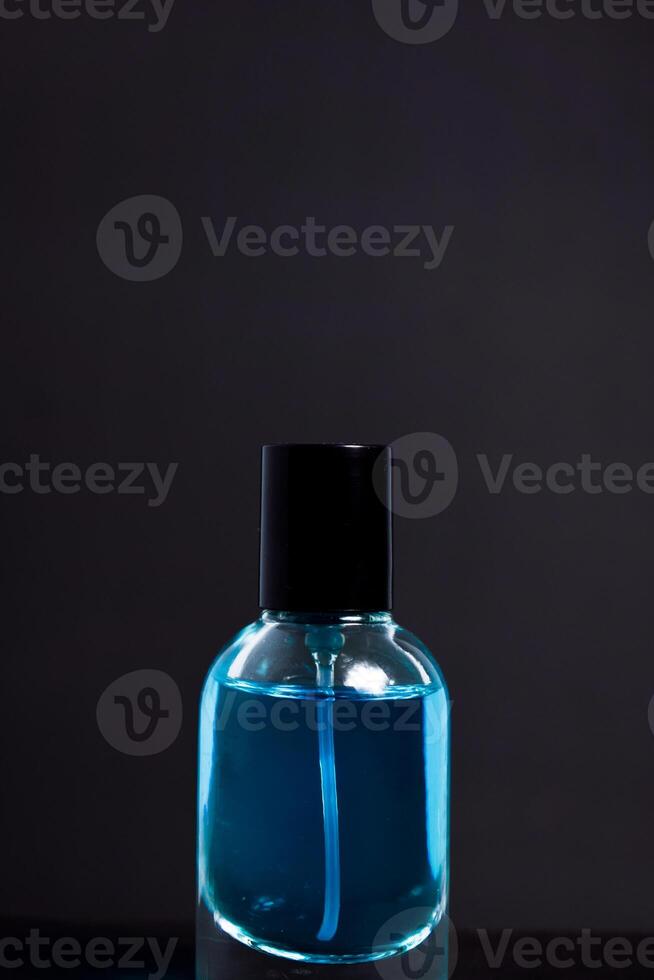 Transparent Blue Bottle Perfume isolated black background for mock up design photo