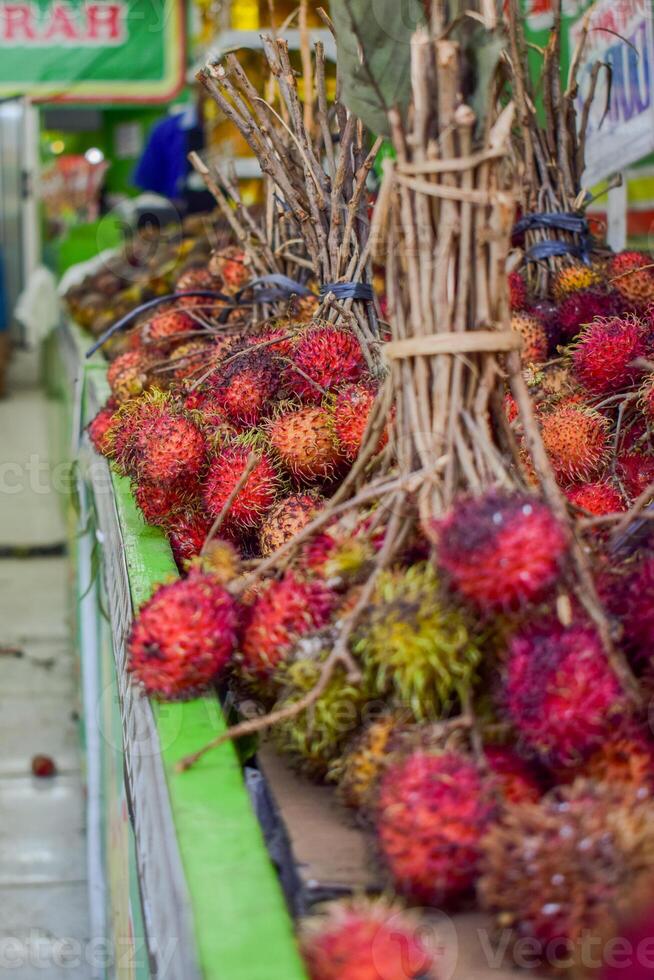 Groups of rambutan fruits displayed in supermarket box photo