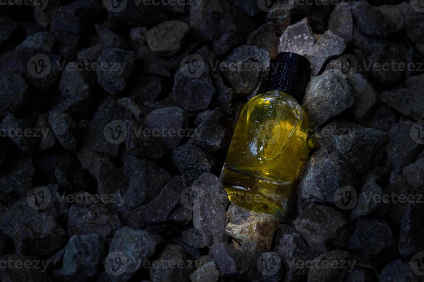 Perfume Yellow transparent bottle in gravel or coral background photo