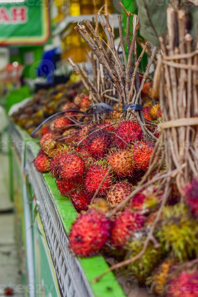 Groups of rambutan fruits displayed in supermarket box photo