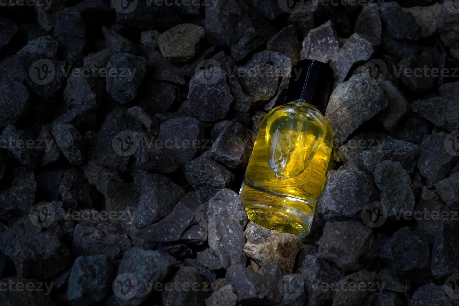 Perfume Yellow transparent bottle in gravel or coral background photo
