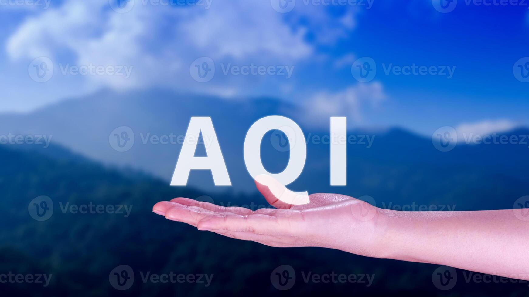 AQI, Abbreviation of air quality index, hand holding AQI on nature background, environment concept. photo