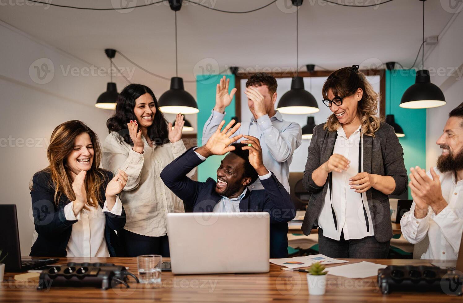 Multiracial business team celebrating success inside modern office - Entrepreneurs people concept photo