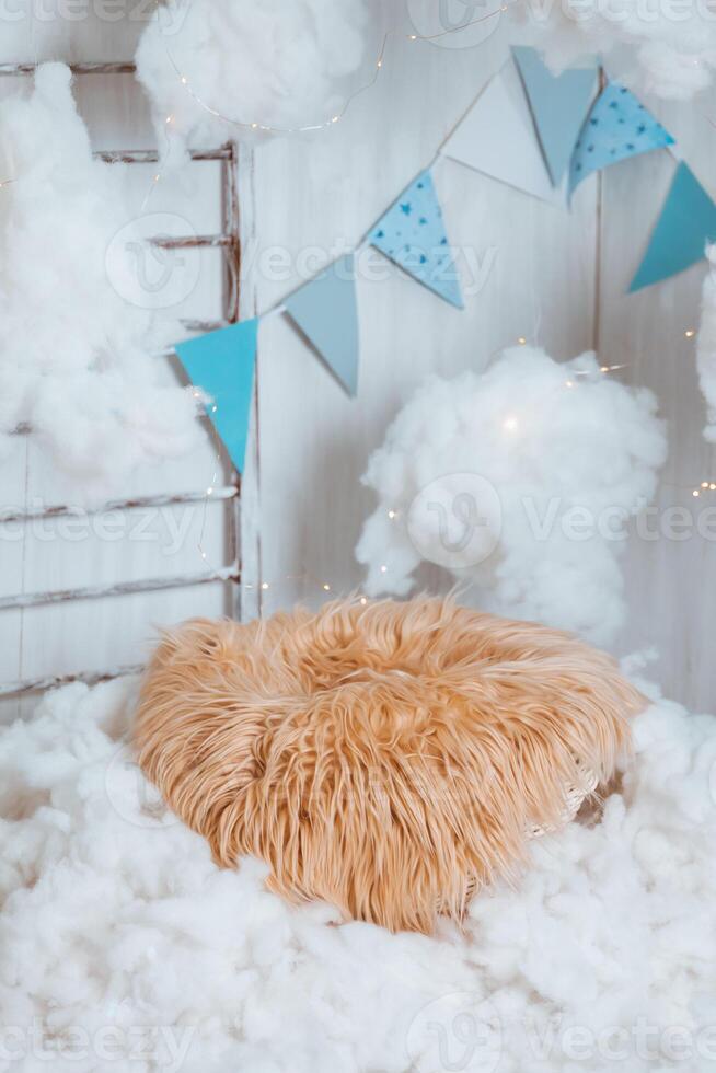 Photo zone for newborns - a basket with fur in the clouds with stars, stairs and flags