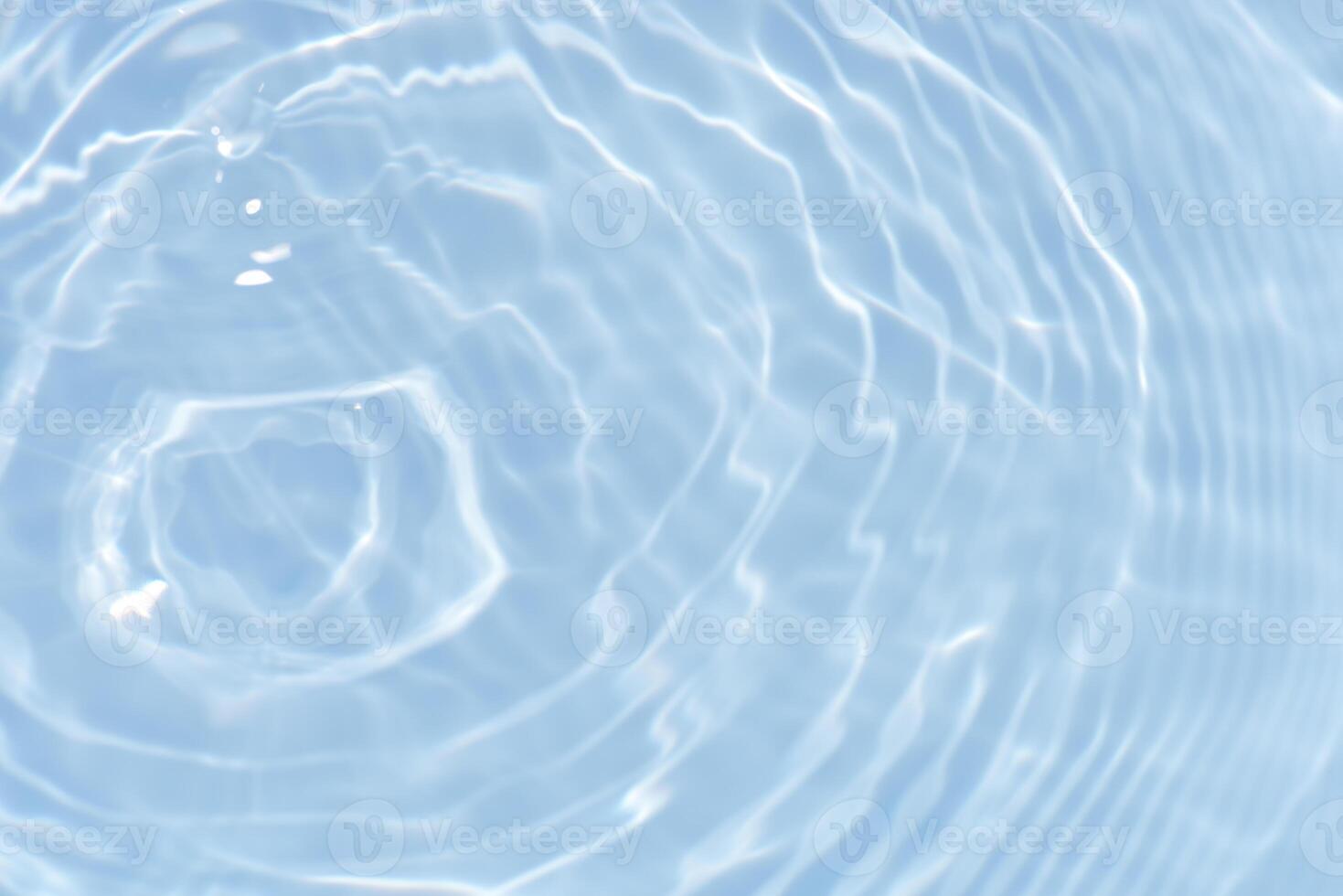 Bluewater waves on the surface ripples blurred. Defocus blurred transparent blue colored clear calm water surface texture with splash and bubbles. Water waves with shining pattern texture background. photo