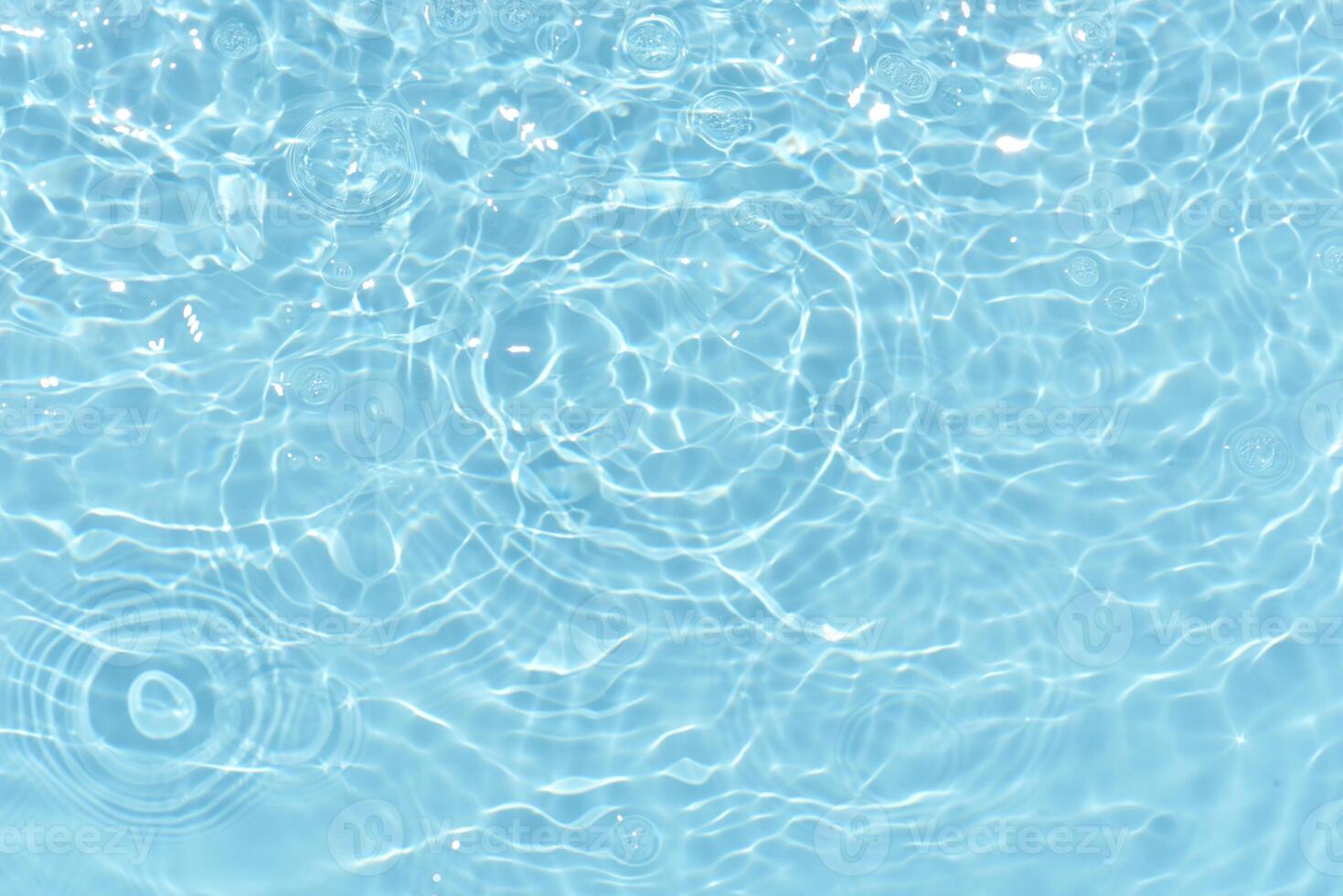 Bluewater waves on the surface ripples blurred. Defocus blurred transparent blue colored clear calm water surface texture with splash and bubbles. Water waves with shining pattern texture background. photo