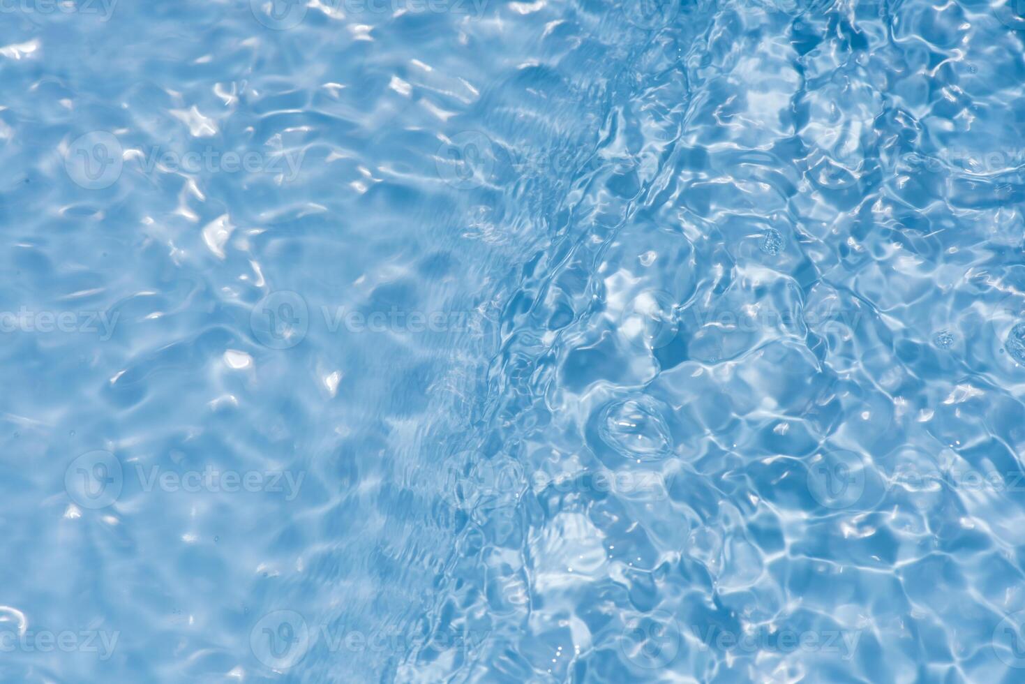 Bluewater waves on the surface ripples blurred. Defocus blurred transparent blue colored clear calm water surface texture with splash and bubbles. Water waves with shining pattern texture background. photo