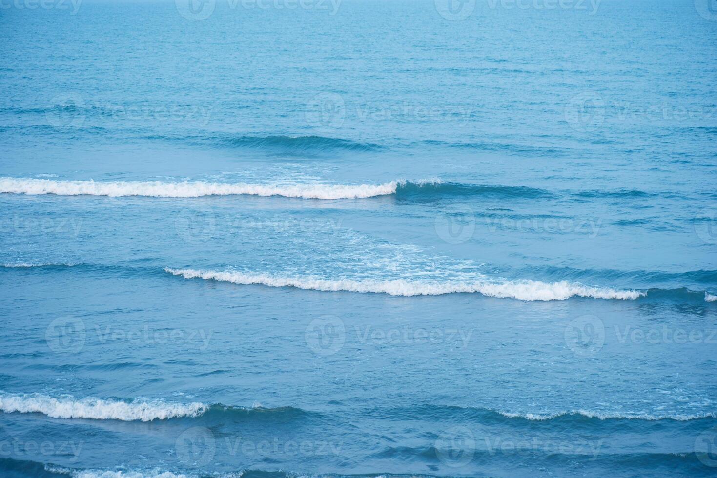 Bluewater waves on the surface ripples blurred. Defocus blurred transparent blue colored clear calm water surface texture with splash and bubbles. Water waves with shining pattern texture background. photo