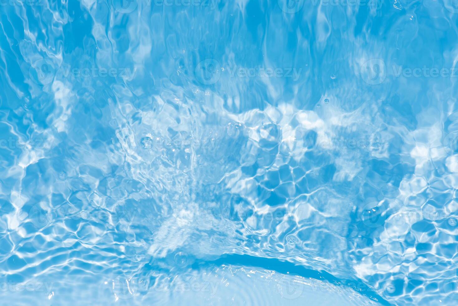 Bluewater waves on the surface ripples blurred. Defocus blurred transparent blue colored clear calm water surface texture with splash and bubbles. Water waves with shining pattern texture background. photo