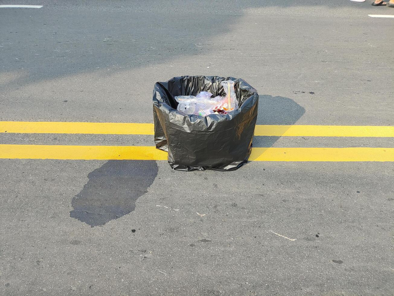 un basura lata es previsto en el medio de el principal la carretera durante coche gratis día en Surakarta, Indonesia foto