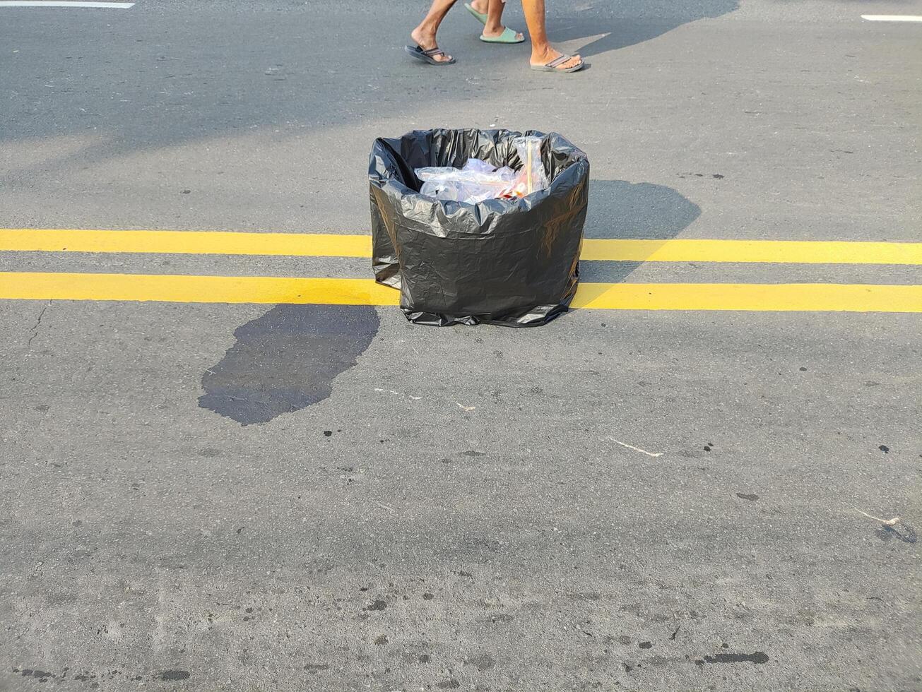 un basura lata es previsto en el medio de el principal la carretera durante coche gratis día en Surakarta, Indonesia foto