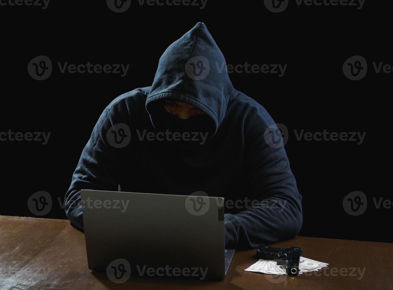 retrato hacker espía hombre uno persona en negro capucha sentado en mesa mirando computadora ordenador portátil usado iniciar sesión contraseña ataque seguridad a datos digital Internet red sistema noche oscuro antecedentes Copiar espacio foto