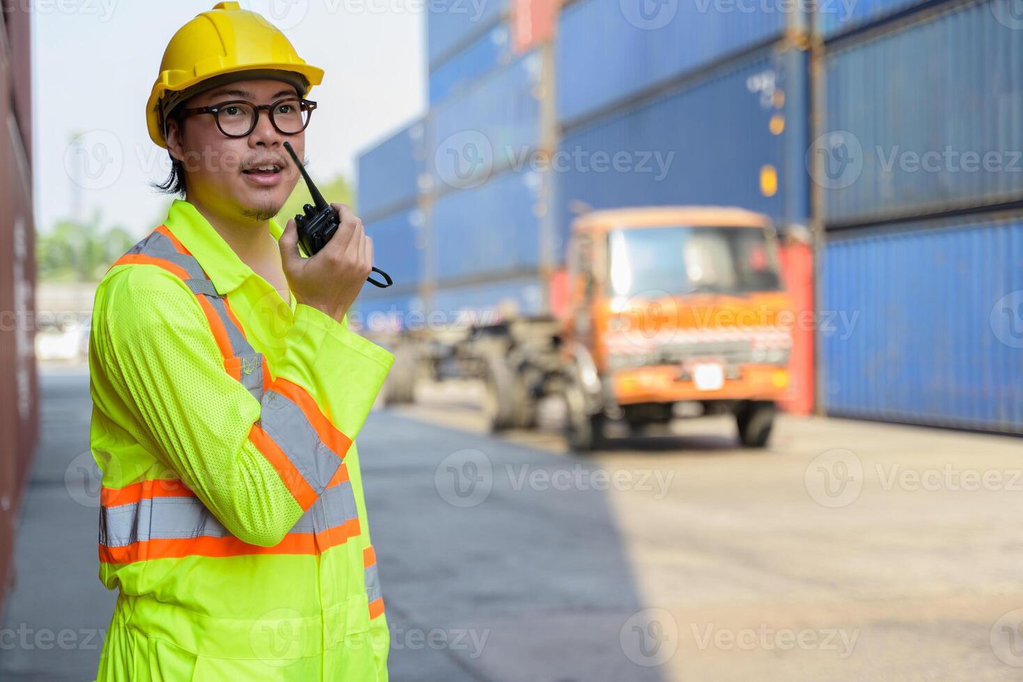 asiático hombre trabajador hablando en walkie película sonora a conductor para controlar cargando contenedores caja a carga Envío yarda foto