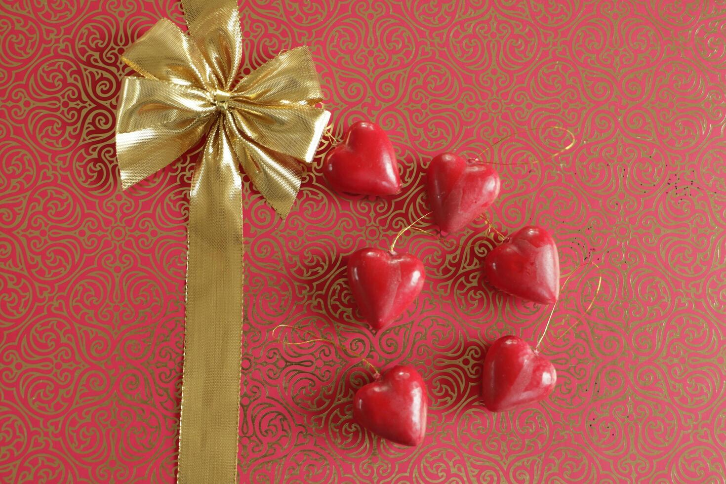 bow in a gold ribbon on a red background, valentines day wishes photo
