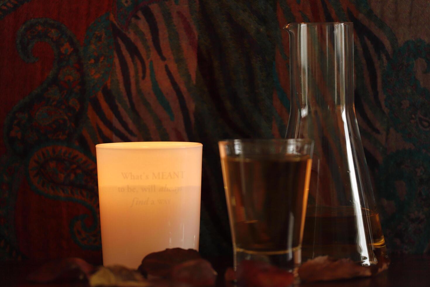 carafe and glass of apple juice and an atmospheric candle photo