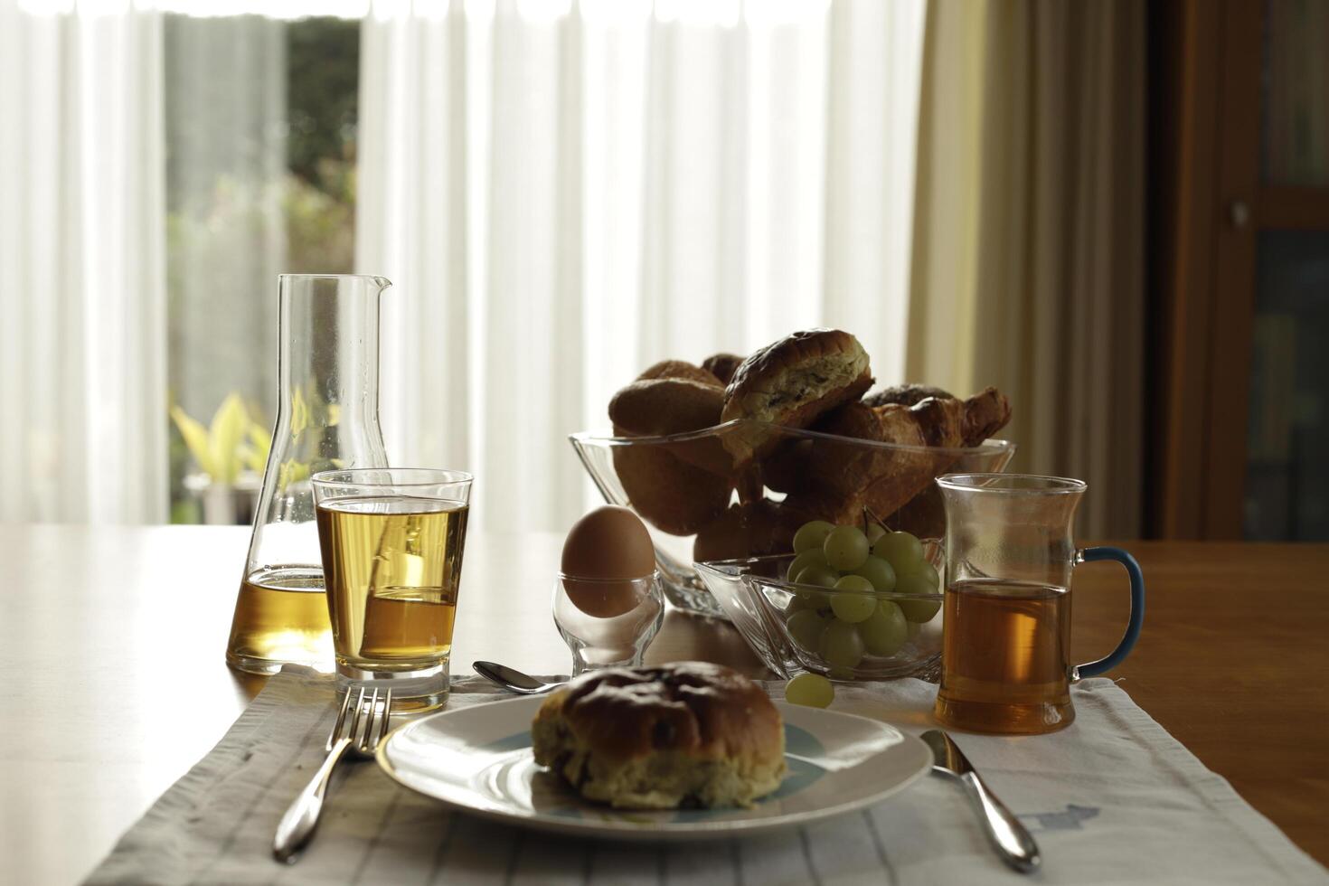 continental breakfast with tea, juice, bread and egg photo