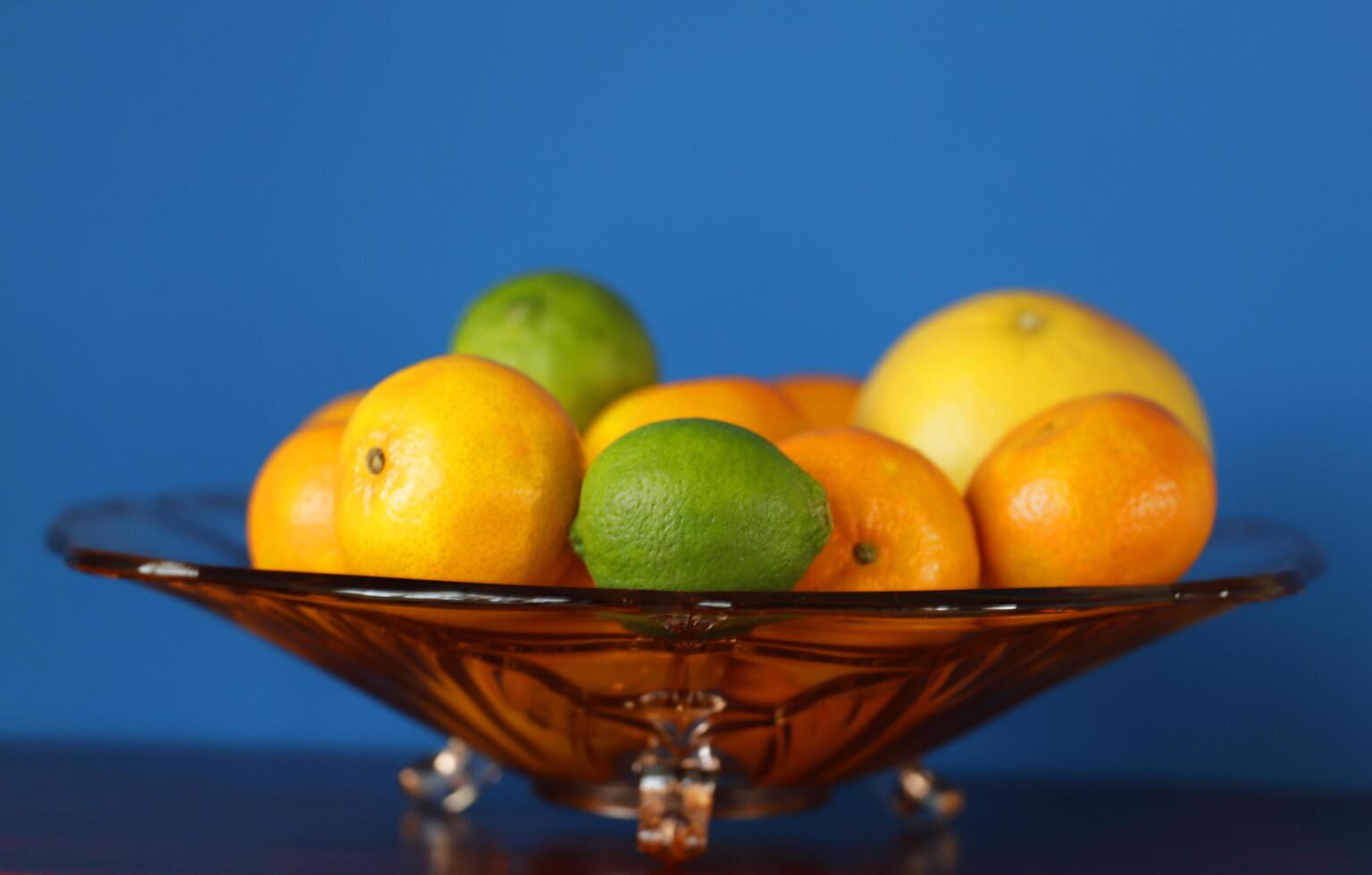 a glass bowl with citrus fruit photo