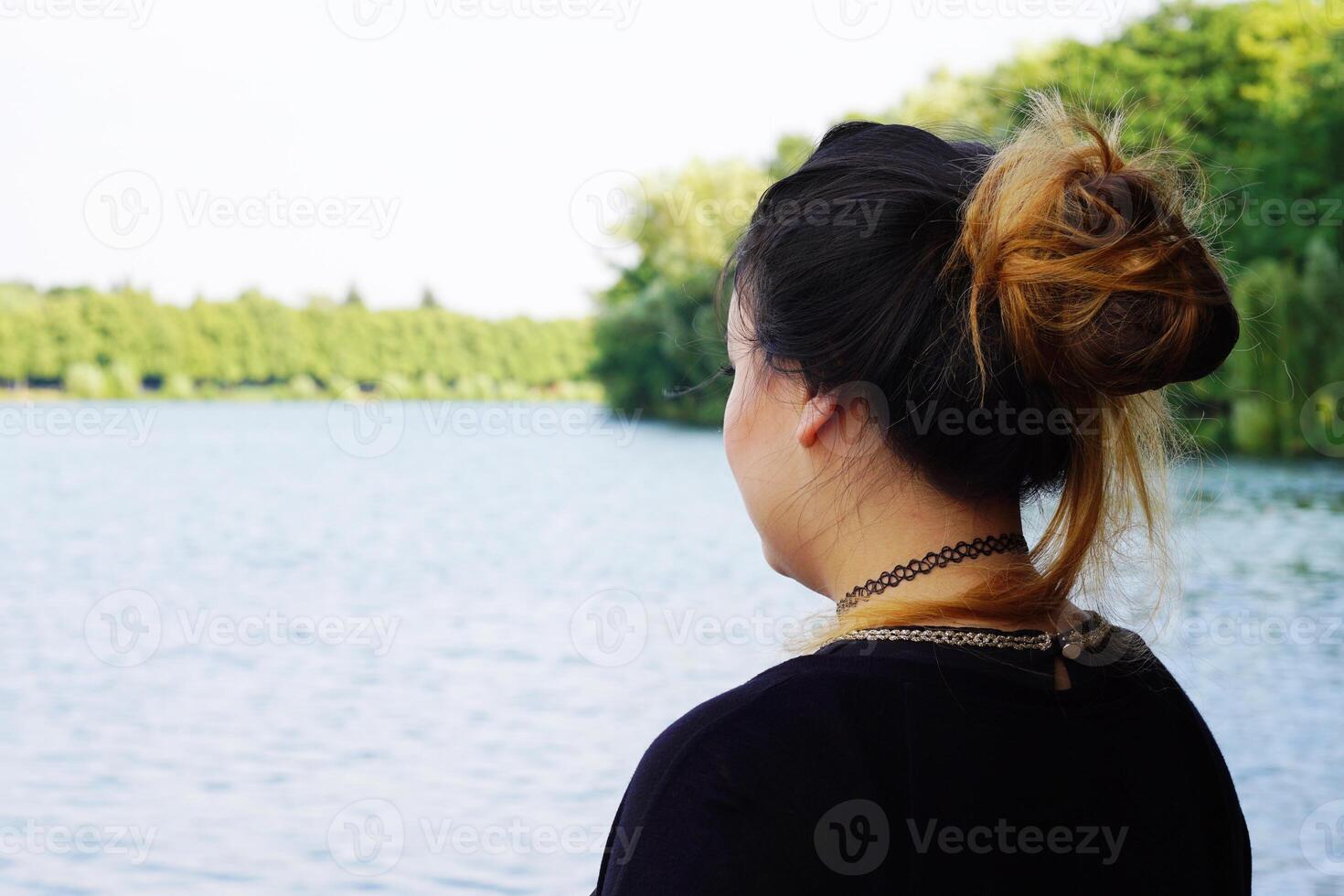 young woman looking over lake photo