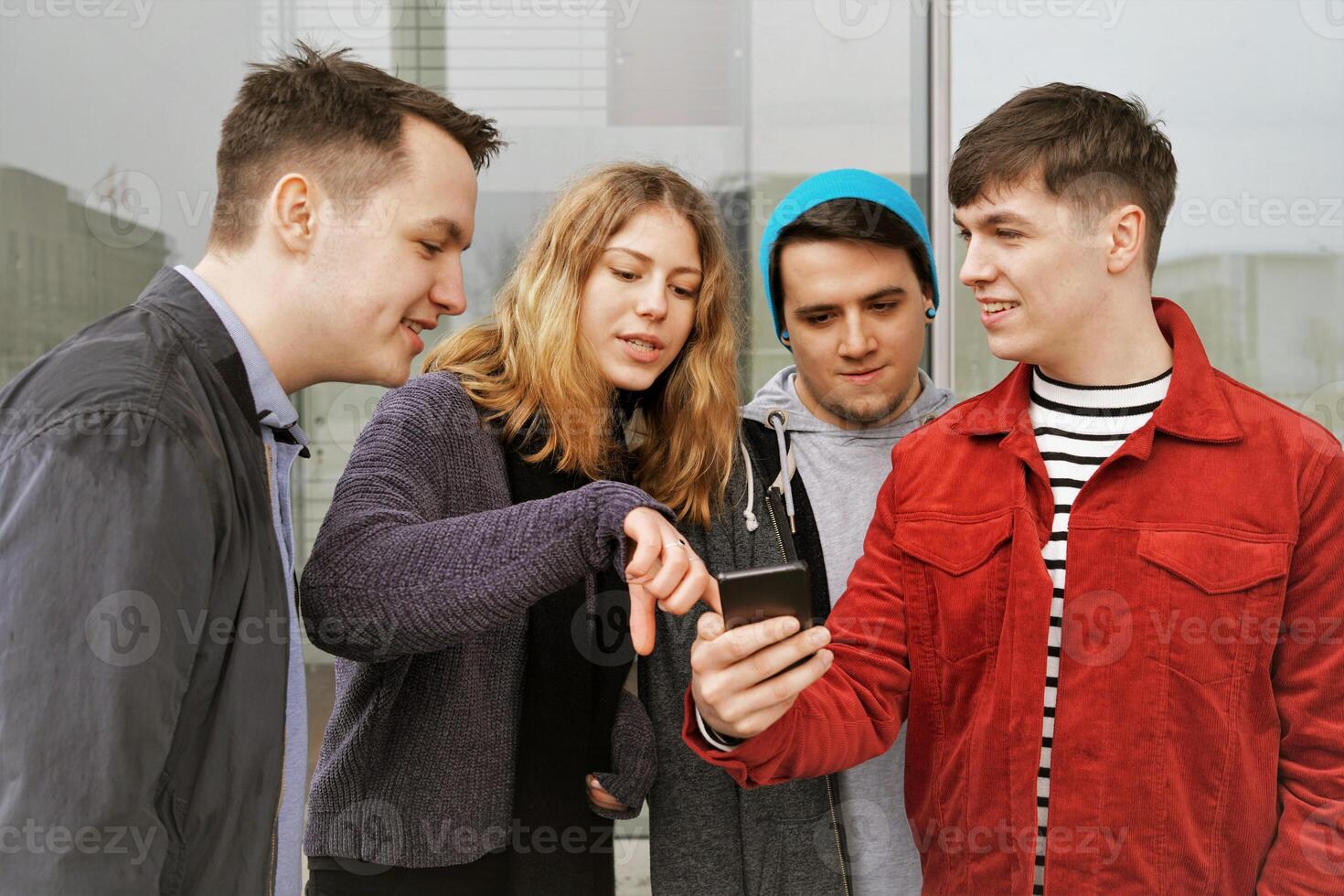 group of teenage friends having a discussion over some mobile phone content photo