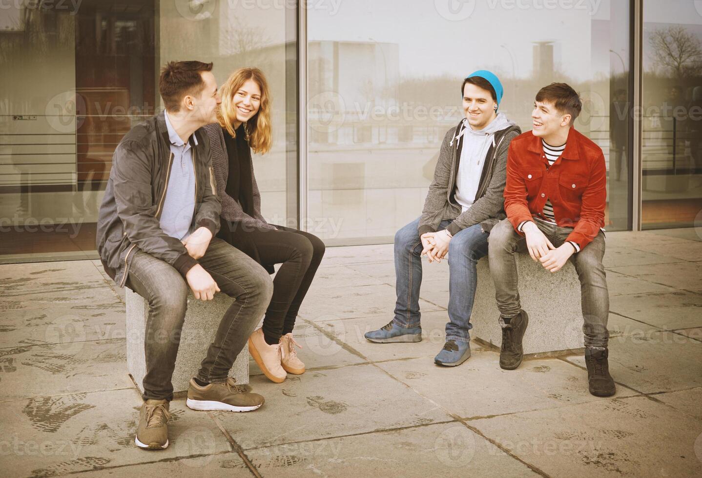 group of young teenage friends talking and laughing together photo